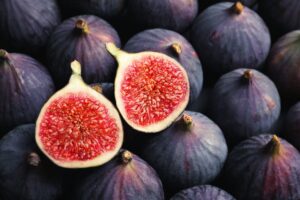A picture of figs with one cut in half showing the center flesh.